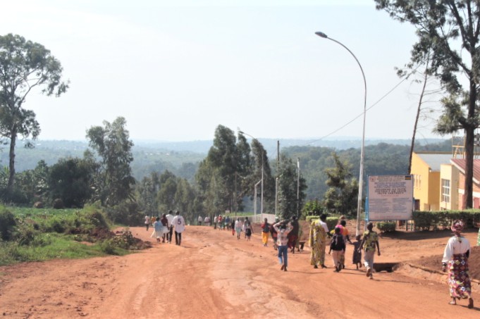 Rwandans walking down a steep dirt road to return home after church.